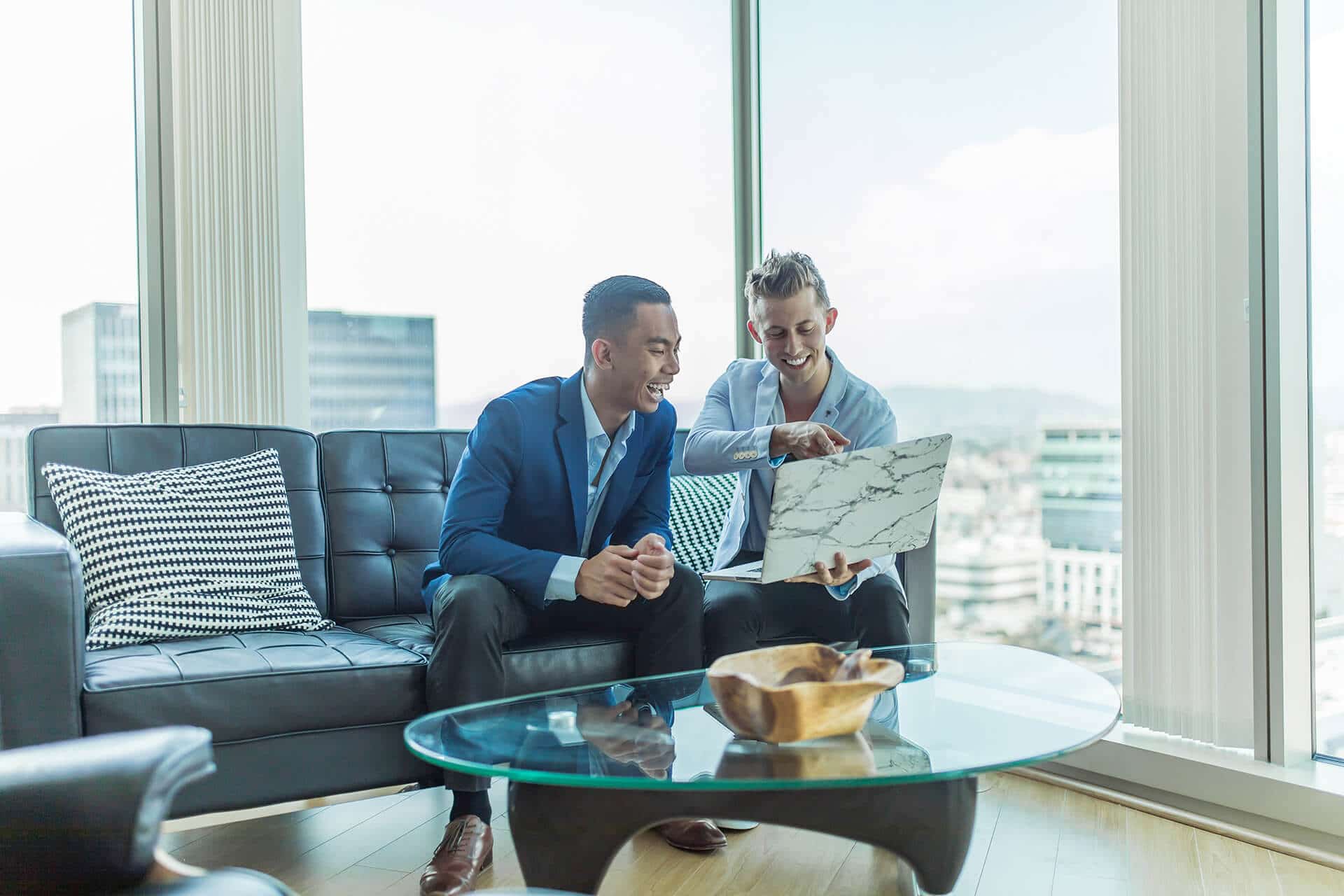 Two people looking at laptop - Buy/Sell Banner