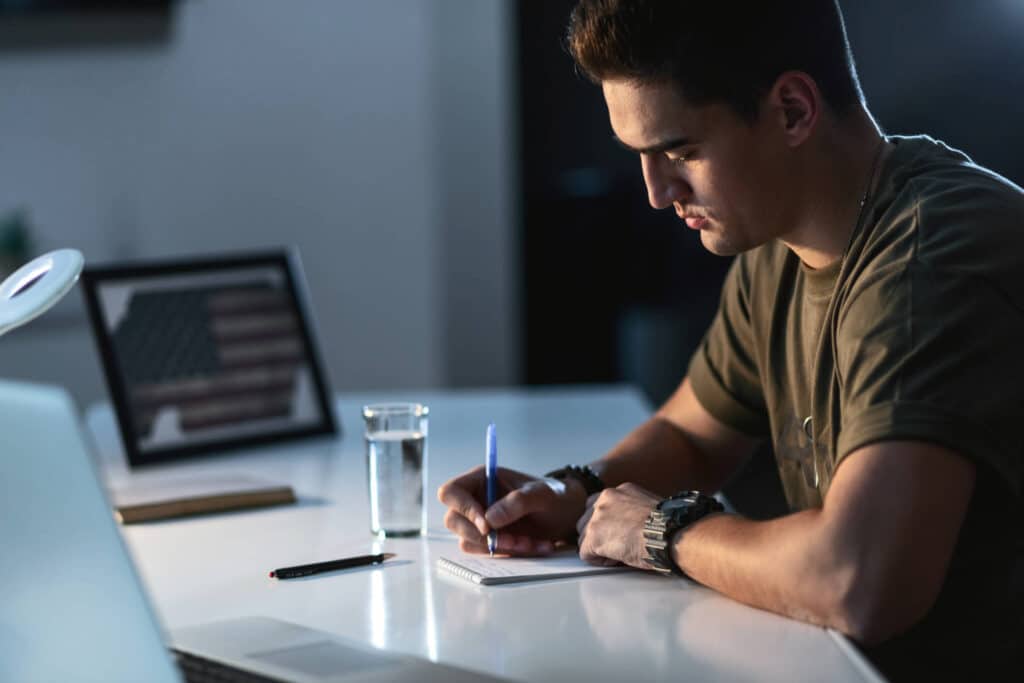 A soldier sitting at a desk and making notes about his investment property.